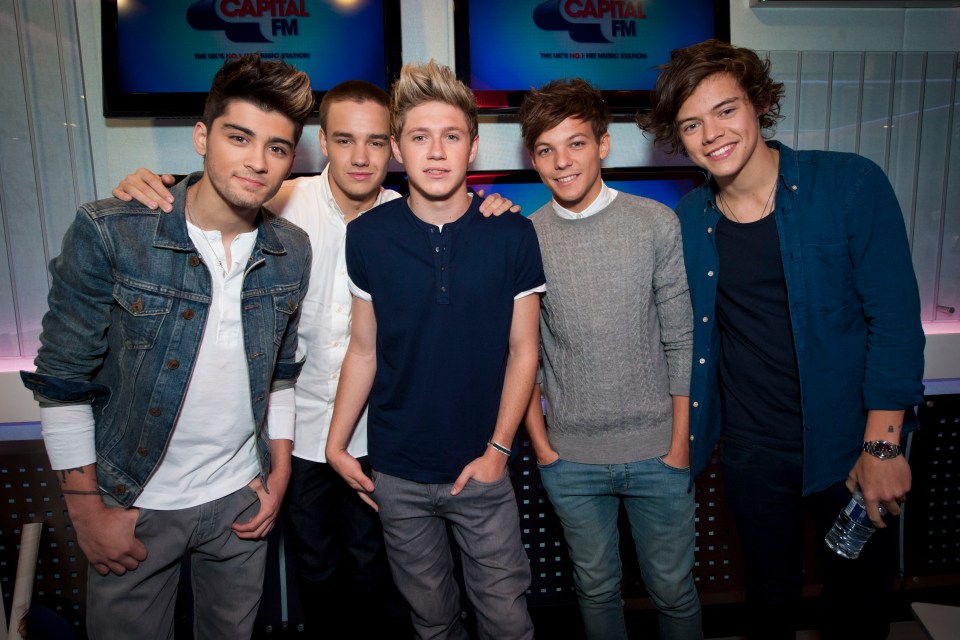 a group of young men are posing for a picture in front of a screen that says capital fm