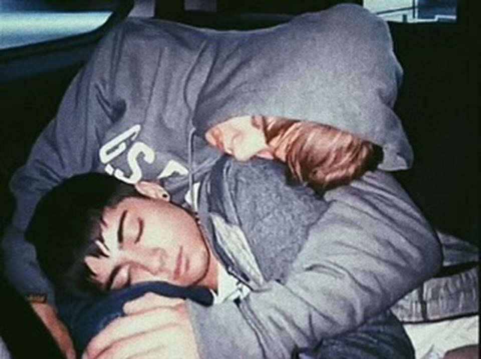 a man and a woman are sleeping in a car .