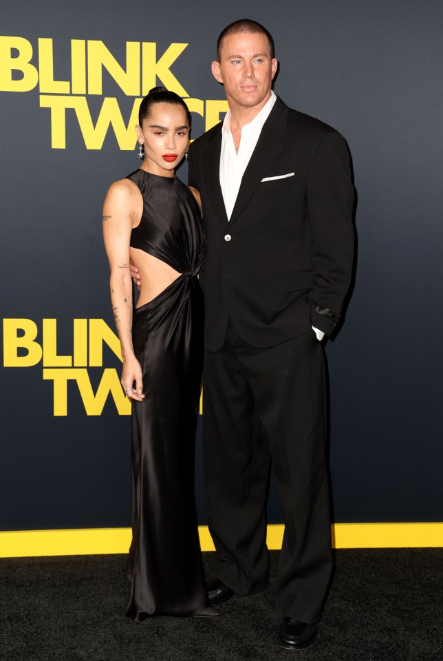 a woman in a black dress and a man in a suit pose on the red carpet for a movie called blink