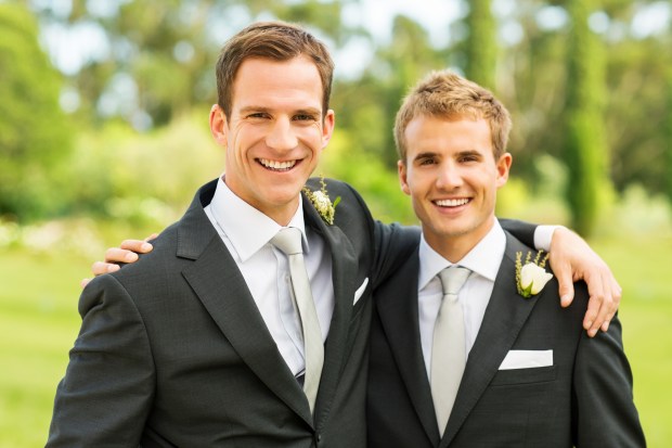 two men in suits are posing for a picture and one has his arm around the other 's shoulder