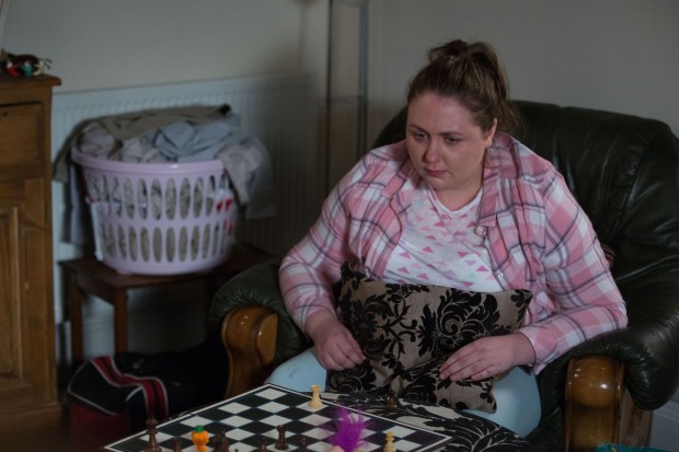 a woman sits in a chair playing a game of chess