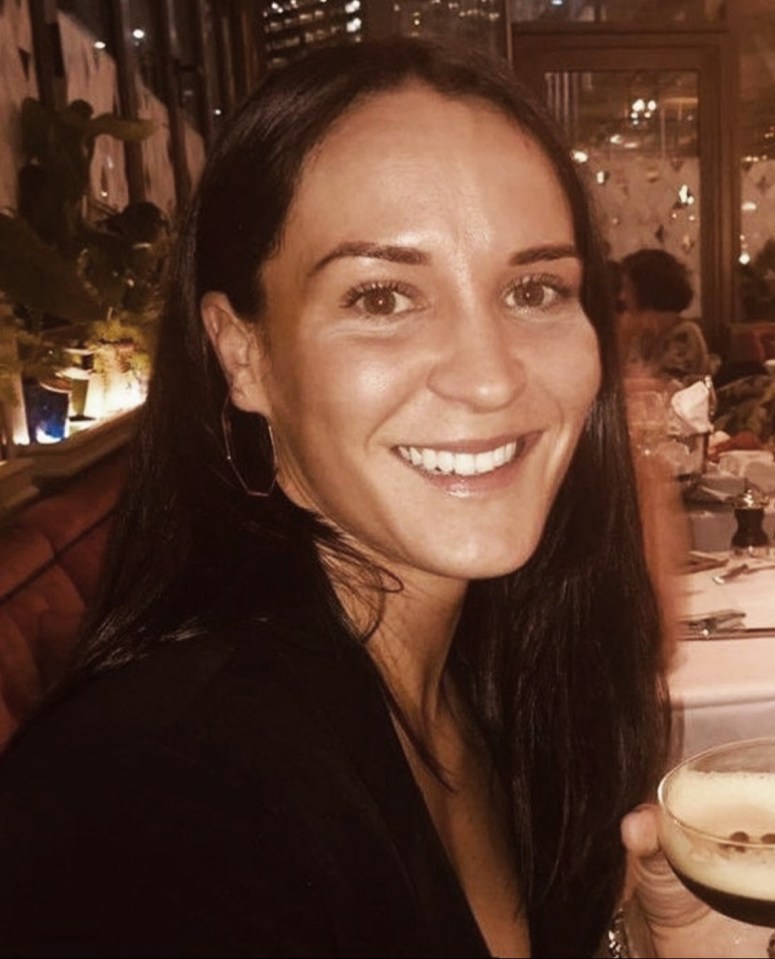 a woman is smiling while holding a glass of wine