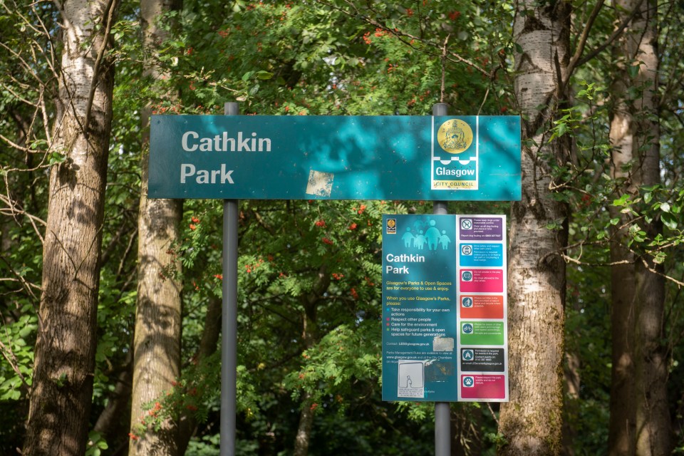 a sign for cathkin park is surrounded by trees