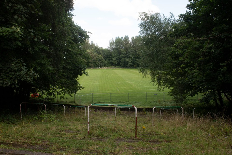 a soccer field that is surrounded by trees