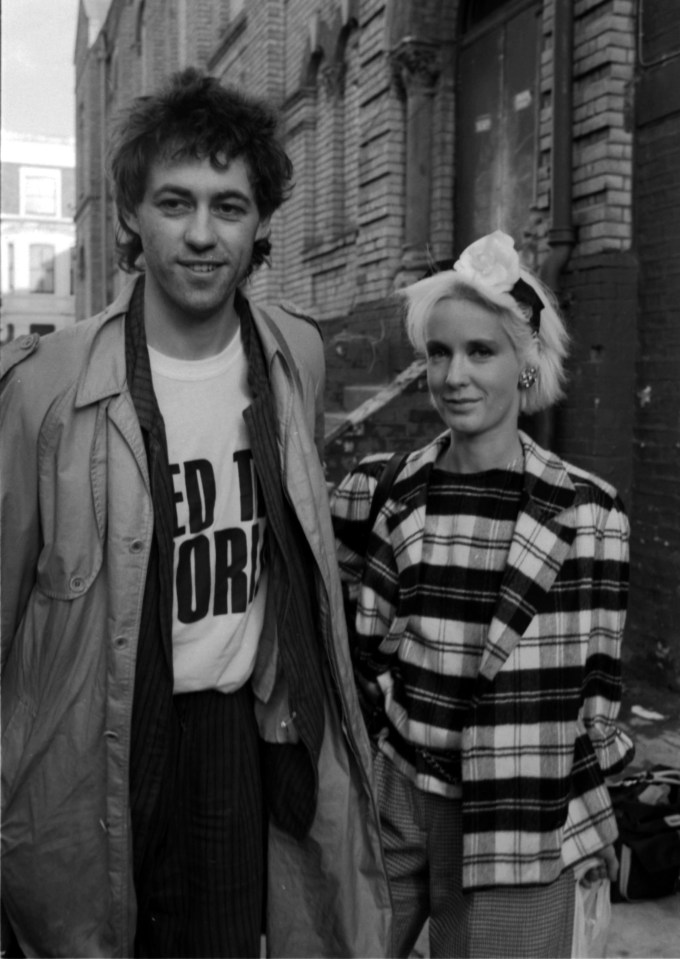 a man wearing a t-shirt that says " ed to or " stands next to a woman