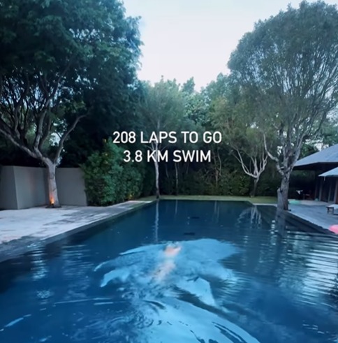 a person is swimming in a pool with the words " 208 laps to go 3.8 km swim "