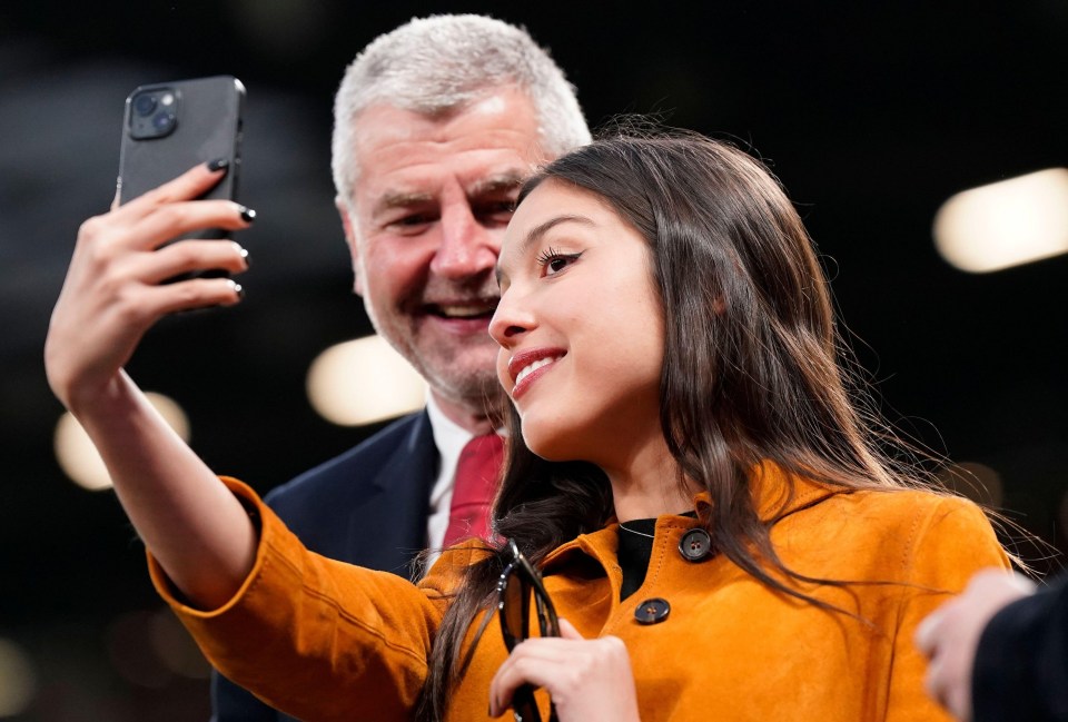 a woman taking a selfie with a man in a suit