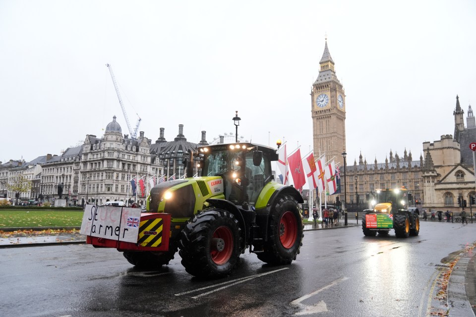 two claas tractors are driving down a street in front of big ben