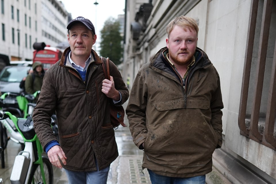 two men are walking down a street and one has a hat that says ' abercrombie & fitch ' on it