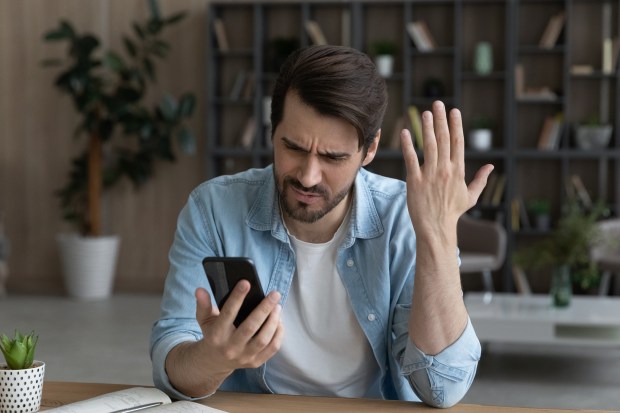 a man sitting at a table looking at his cell phone