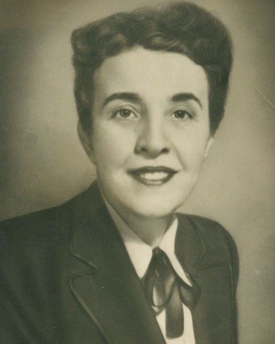 a black and white photo of a woman in a suit and tie