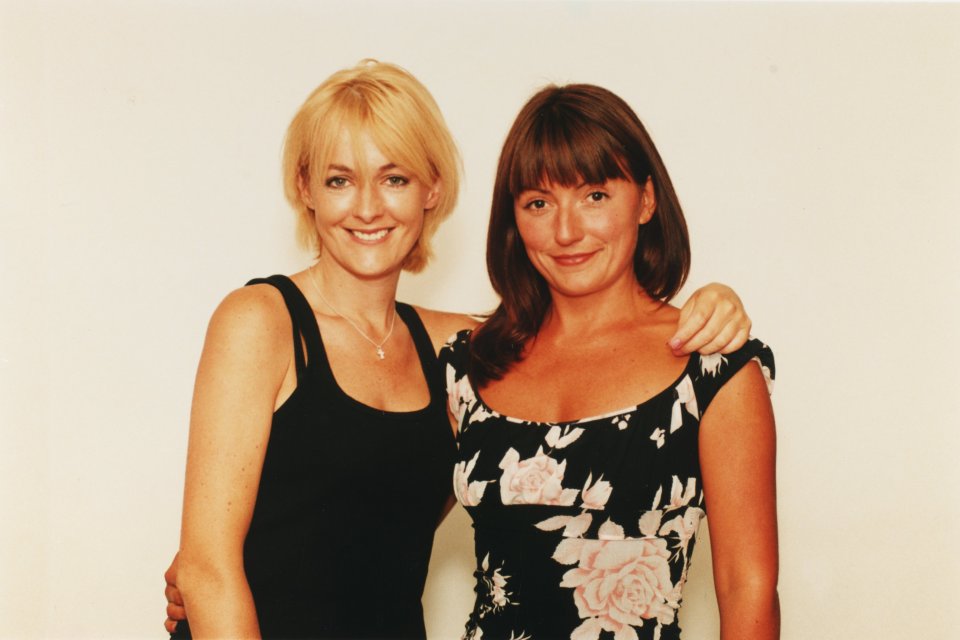 two women posing for a picture with one wearing a floral dress