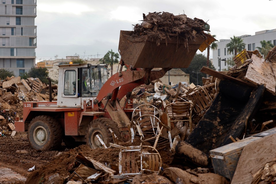 A bulldozer removes debris that was swept away during the flash floods in La Torre, in the province of Valencia