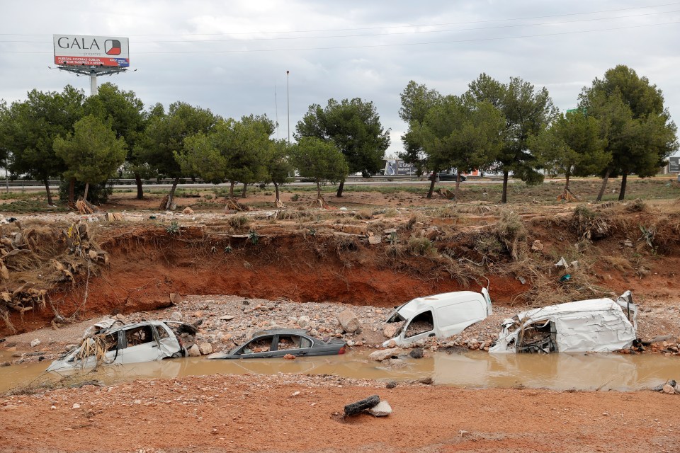 A view of damaged cars semi-buried in a ravine after this week's flash floods