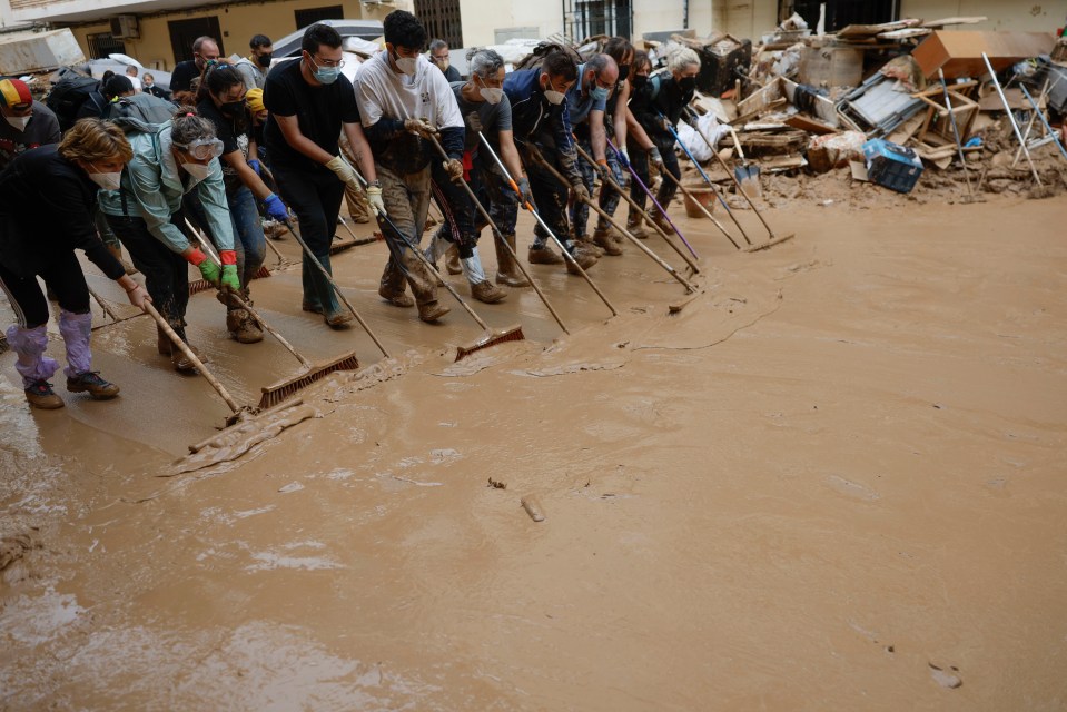 Locals work together to get rid of water that has not yet drained away