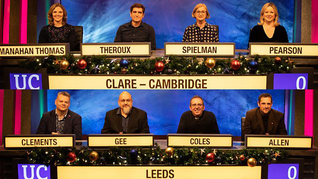 a group of people are sitting in front of a sign that says clare cambridge