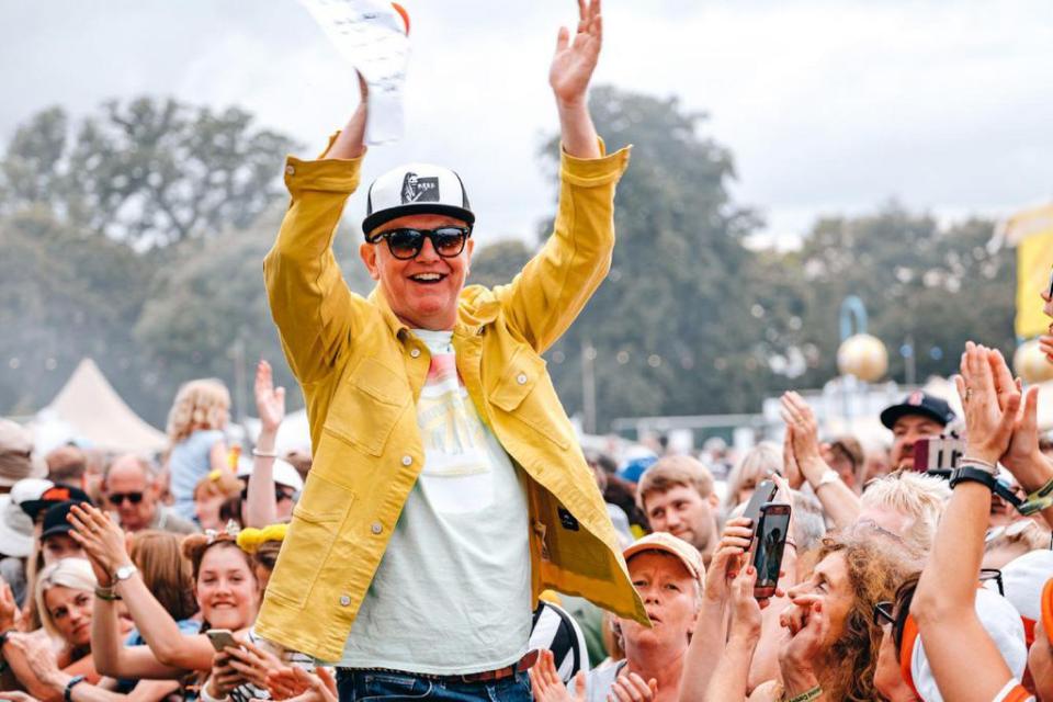 a man wearing a yellow jacket and a hat that says ' snoop dogg ' on it