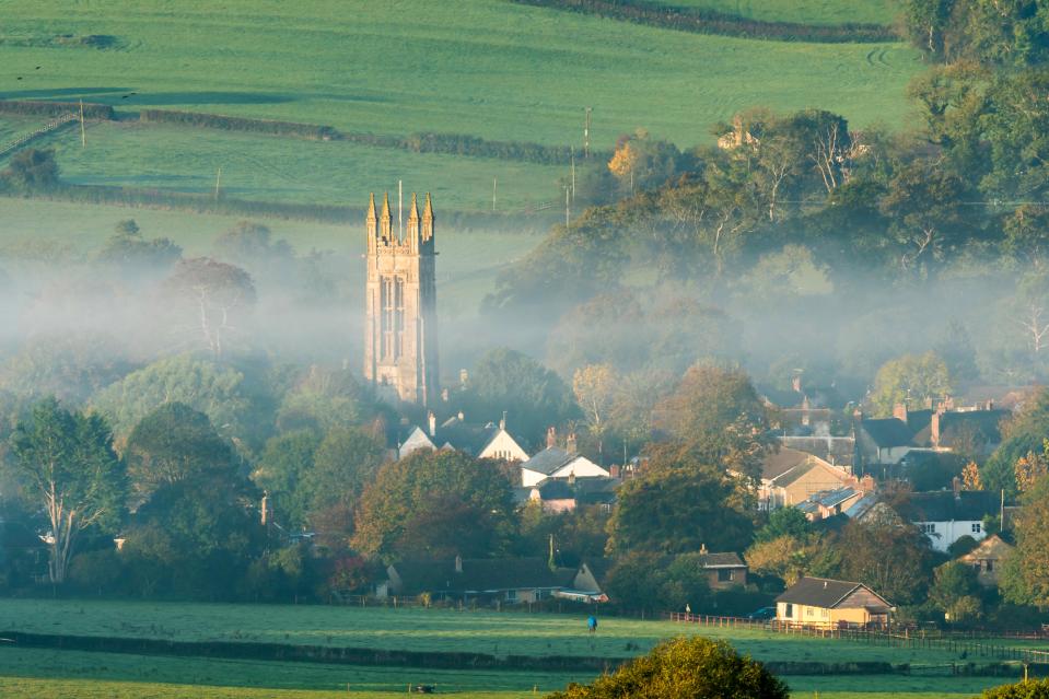 a foggy village with a church in the middle