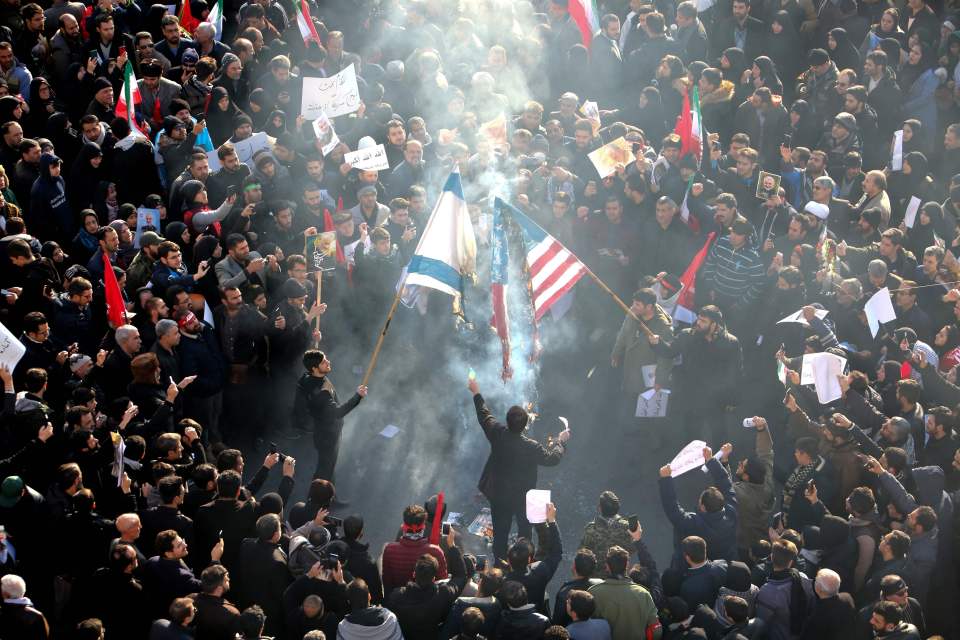 Iranians set a US and an Israeli flag on fire during a funeral procession organised to mourn military commander Qasem Soleimani after a US attack in Tehran in 2020