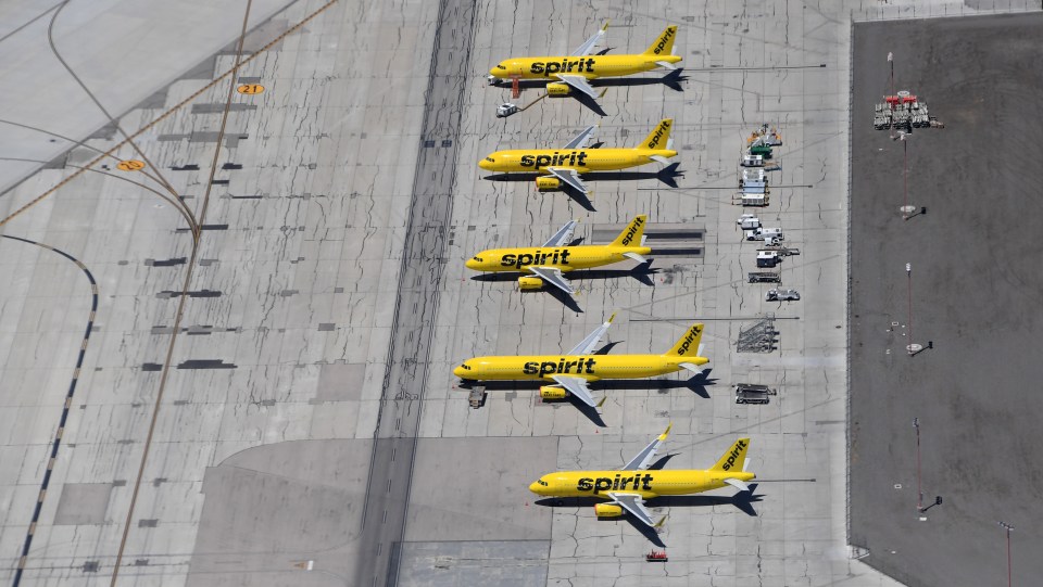 several spirit planes are parked on the runway