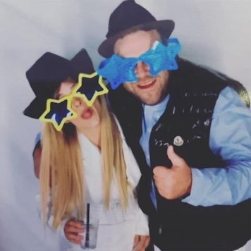 a man and a woman wearing sunglasses and hats are posing for a picture .