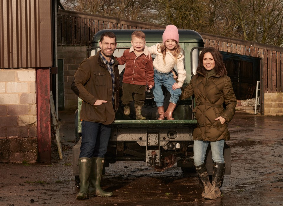 a family posing for a picture in front of a truck that says ' hunter ' on the back