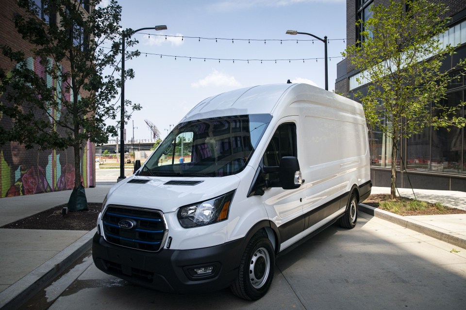 a white ford van is parked on the side of the road