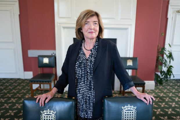 a woman leans on a briefcase with a crown on it