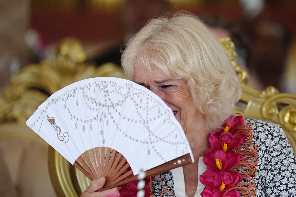 a woman holding a fan with the letter g on it