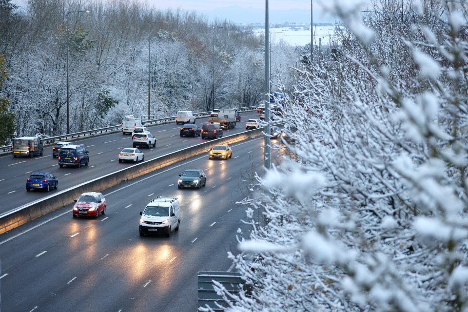 a car is driving down a snowy street at night