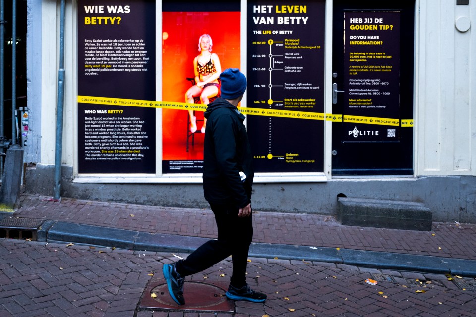 A pedestrian walks past a hologram representing murdered sex worker Bernadette Szabo