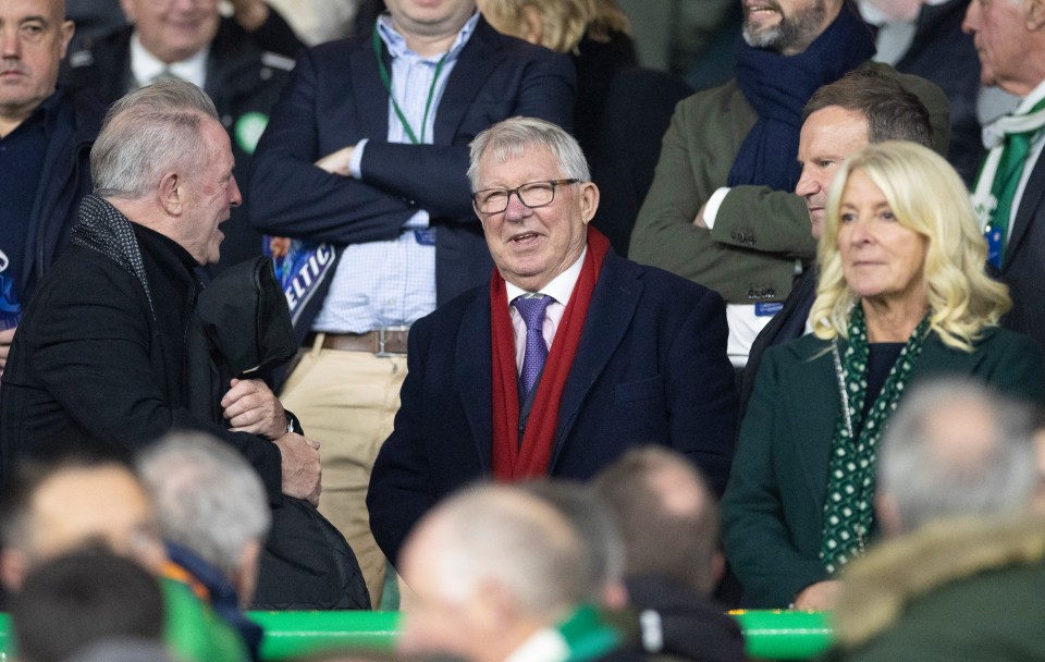 a man wearing glasses and a red scarf talks to another man