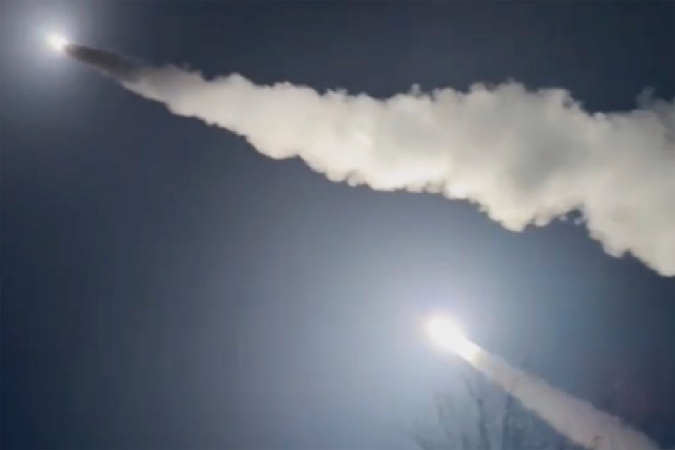 a rocket is flying through a clear blue sky