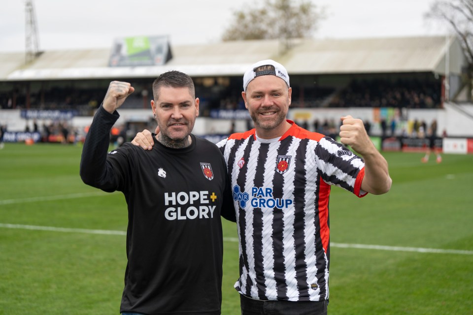 two men on a soccer field with one wearing a shirt that says hope + glory