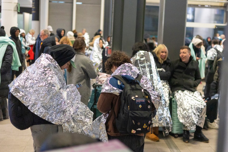 Passengers were seen clinging to reflective blankets to keep the heat in as they waited