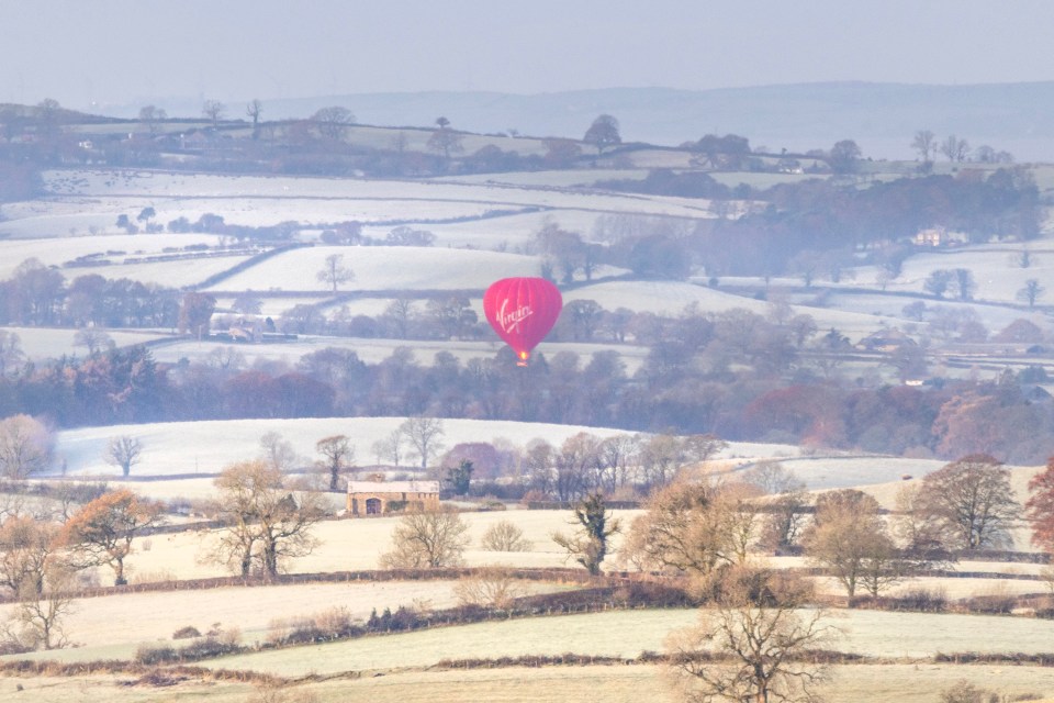 A hot air balloon floats over the Yorkshire Dales