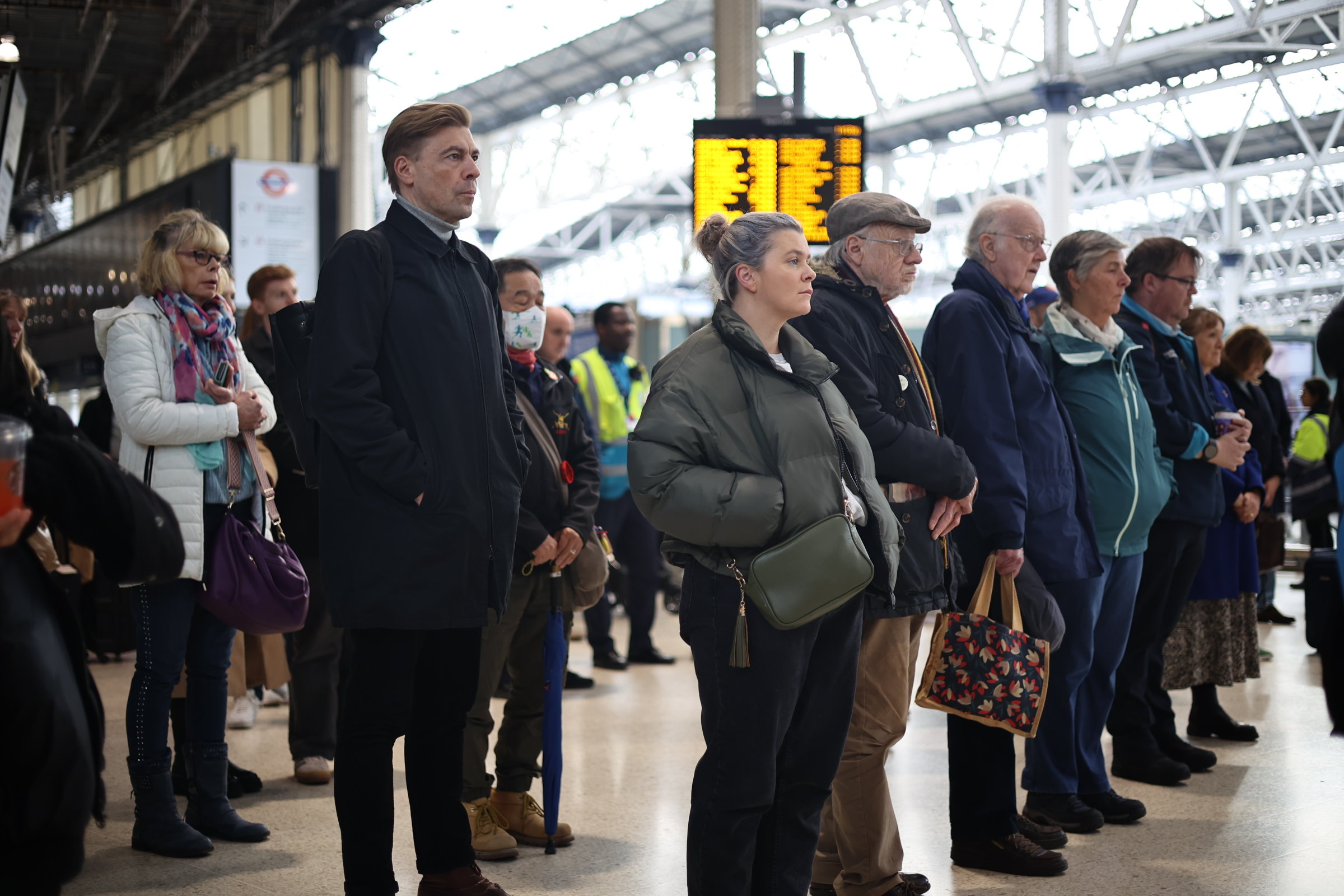 Travellers at a silent Waterloo Station in London at 11am