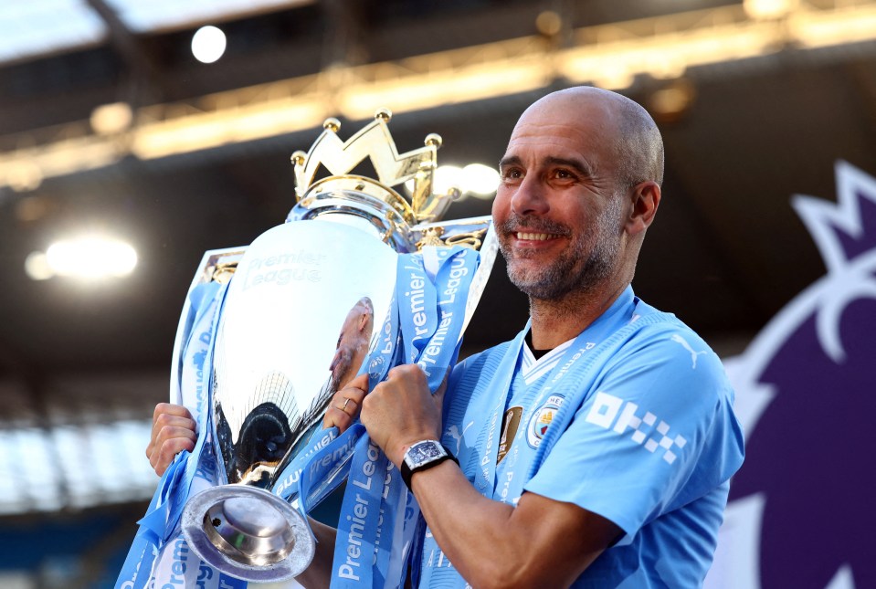 a man holding a trophy that says premier league on it