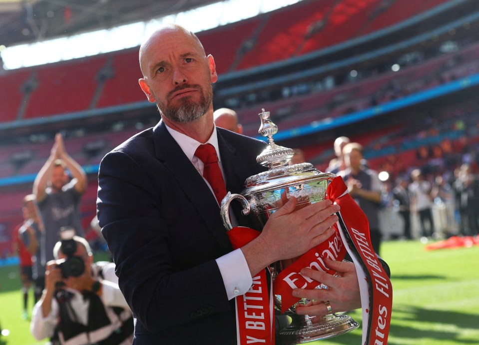 a man holding a trophy that says emirates on it