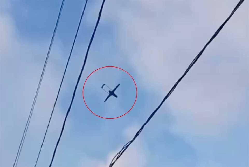 a plane is flying through a blue sky with a red circle around it