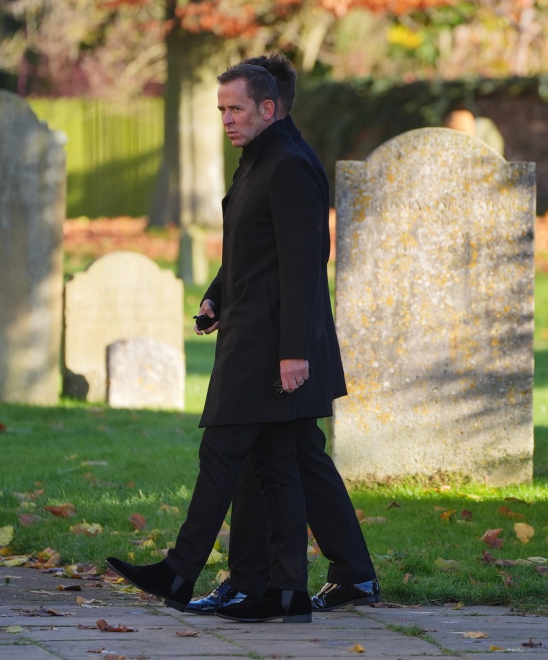 BBC Radio 2 host Scott Mills wore a black long coat over dark trousers