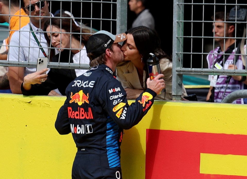 a man in a red bull uniform kisses a woman