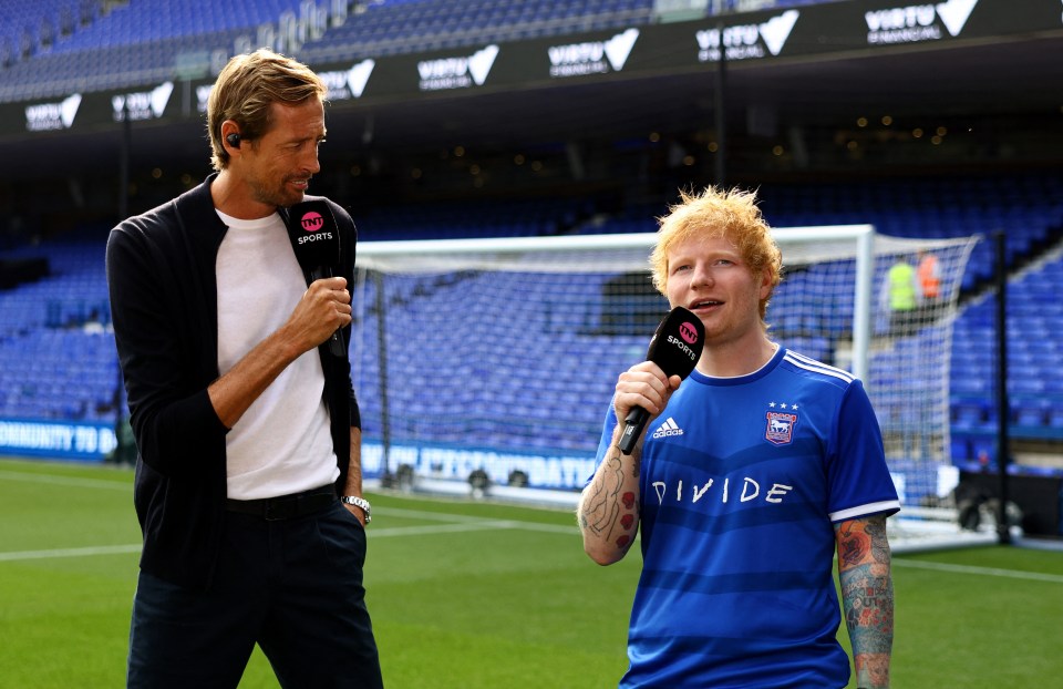 a man wearing a blue divide jersey talks into a microphone