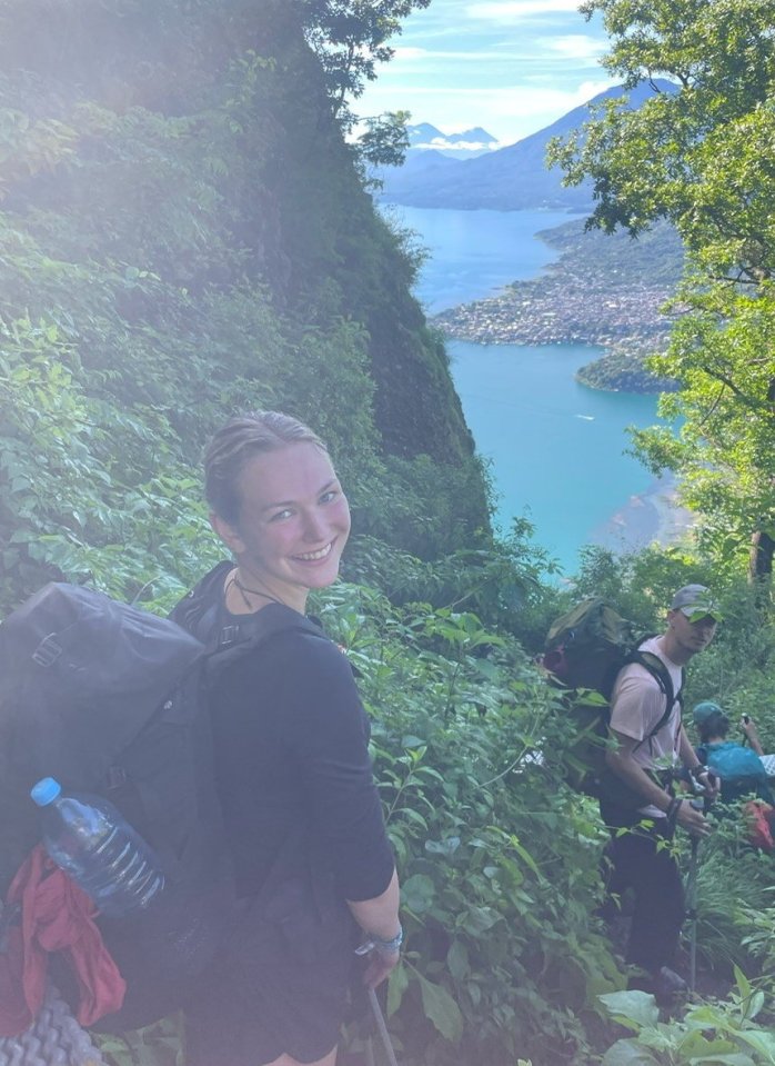 a woman wearing a black backpack with the word osprey on it