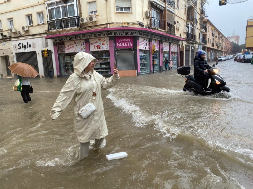 A woman in a flooded street in Malaga