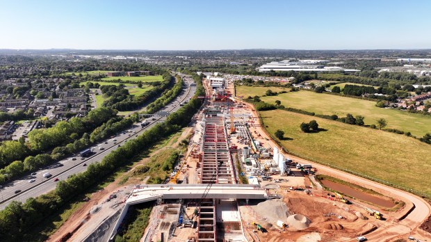 an aerial view of a construction site with a highway in the background