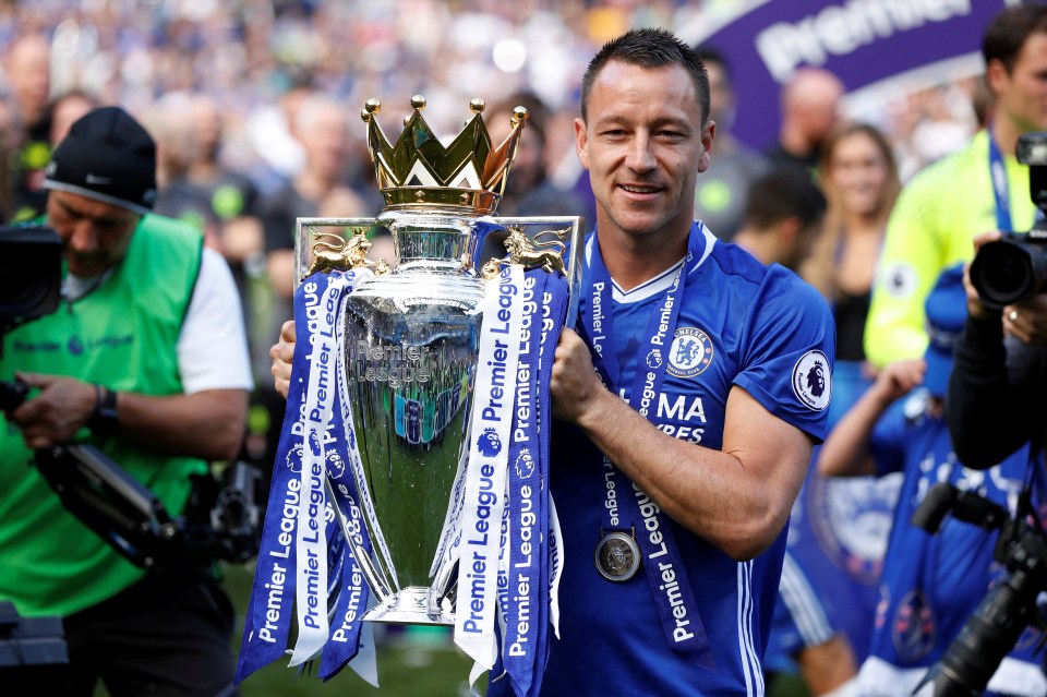 a man holding a trophy that says premier league on it