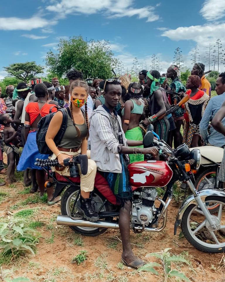 a man sits on a red suzuki motorcycle