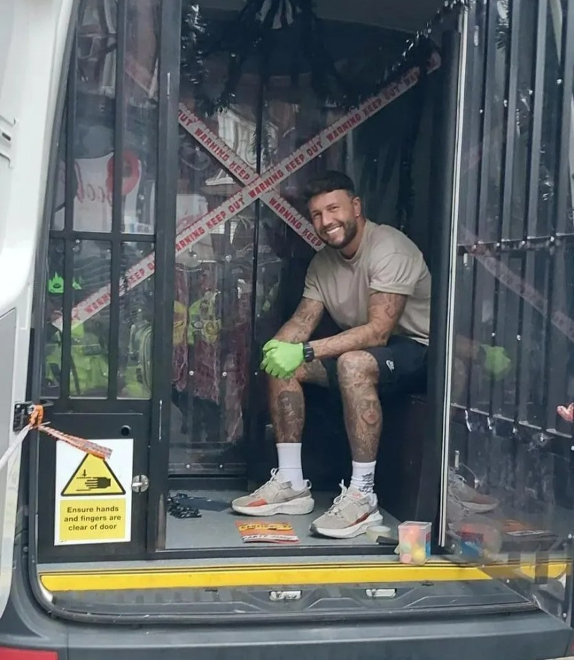 a man sits in the back of a van with a sign that says " do not enter "