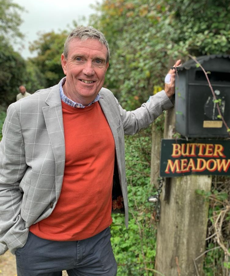 a man stands in front of a sign that says butter meadow